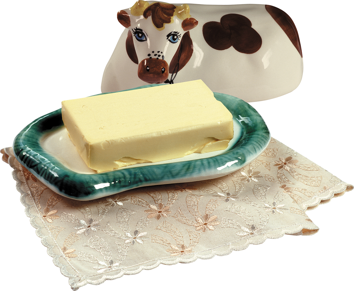 Маслёнка со сливочным маслом и керамическая фигурка коровы. Фото